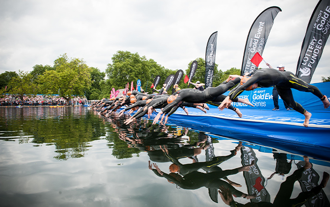 wetsuit swimmers diving into lake wearing wetsuits