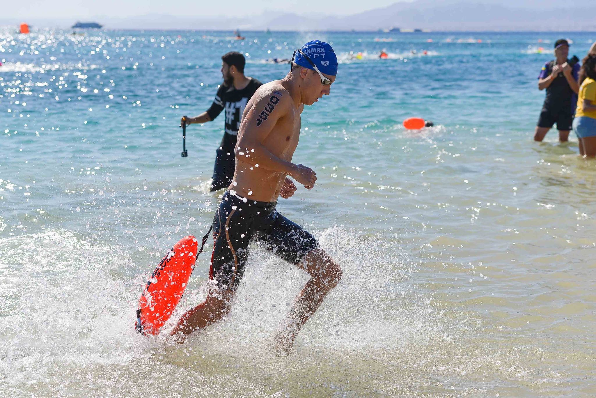 Oceanman swimmer running out of the sea